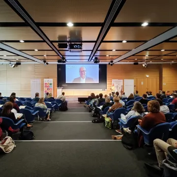 Auditorium mit Screen auf Bühne und Zuschauern im Saal