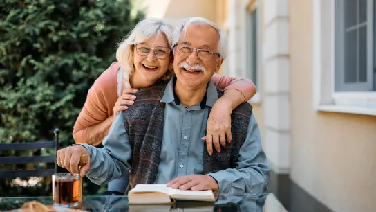 Älteres Paar lachend am Tisch